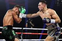 Teofimo Lopez, right, lands a punch against Vasiliy Lomachenko during their lightweight title f ...