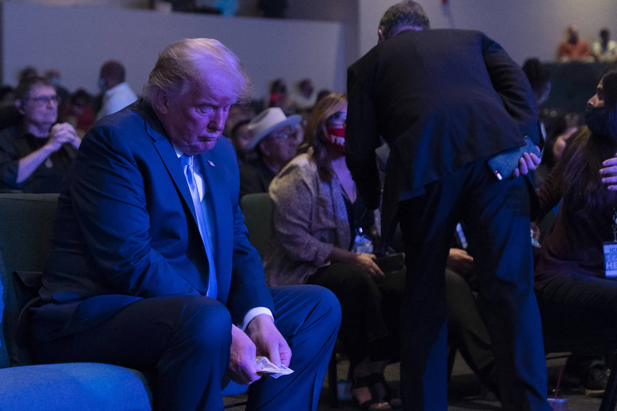President Donald Trump prepares his offering as he attends church at International Church of La ...