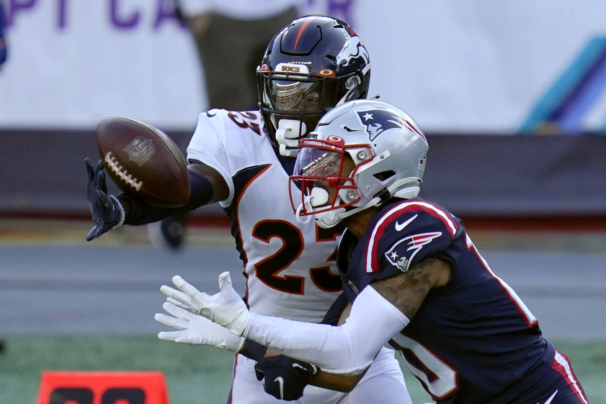Denver Broncos cornerback Michael Ojemudia, rear, breaks up a pass intended for New England Pat ...