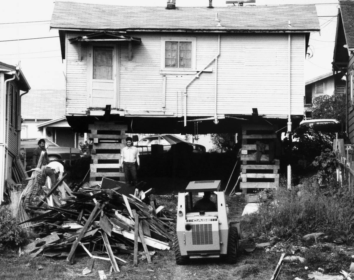 A construction crew works at marking repairs to an elevated and exposed house on a hill, Tuesda ...