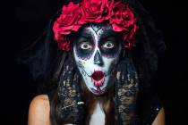 Portrait of woman dressed as catrina, skull to honor the dead in Mexico. Dressed with white fac ...