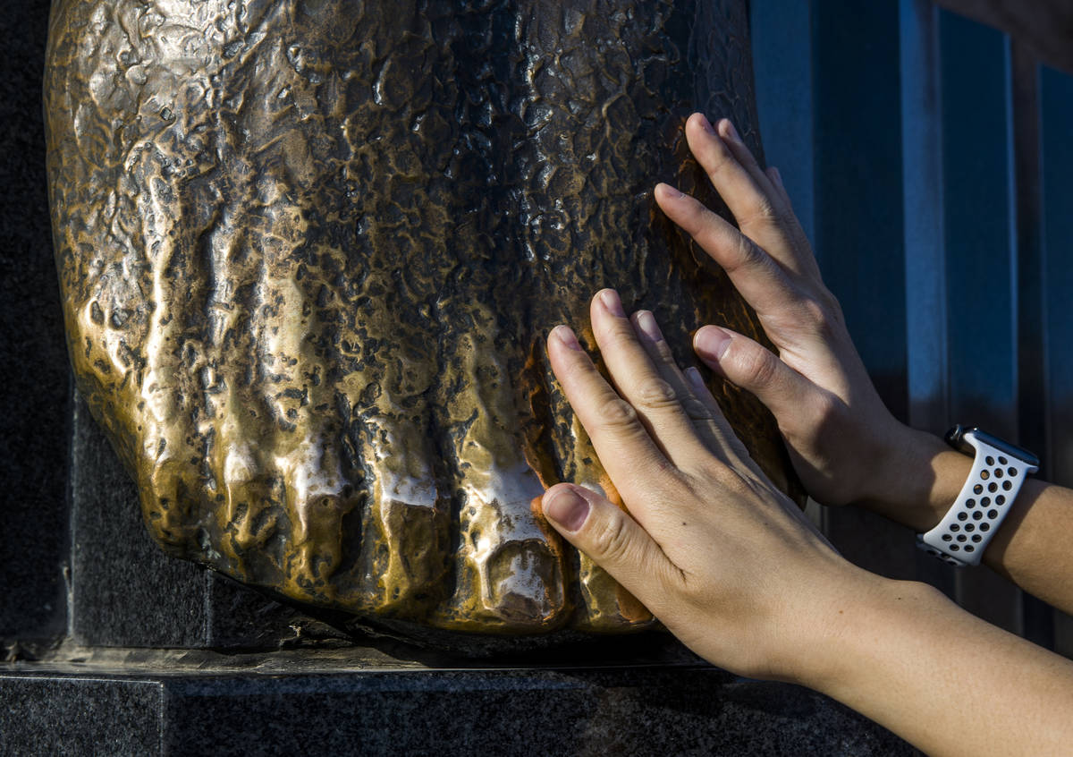 Visitors Molly Panyathong and Johnny Pham of Sacramento, California, touch the feet of the Wing ...