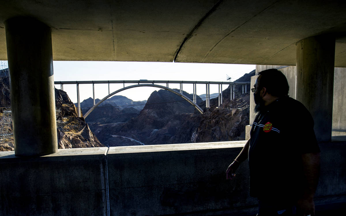 A visitor walks along the top of the Hoover Dam, which opened to the public after being closed ...