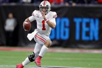 In this Dec. 7, 2019, file photo, Ohio State quarterback Justin Fields (1) runs with the ball a ...