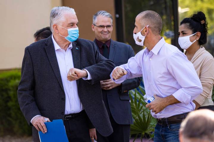 Gov. Steve Sisolak, left, elbow bumps Hans Hippert, owner of Jojo's Jerky, after a press confer ...