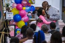 Mario Hunt, right, hugs Mariah Coleman after he recited a poem he wrote for her daughter Sayah ...