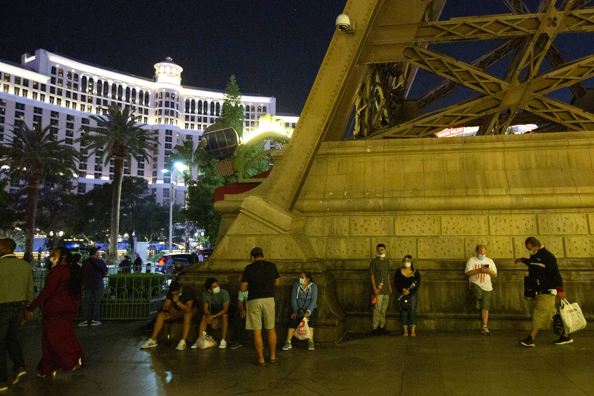 People linger outside Paris Las Vegas following a power outage, which resulted in a building ev ...