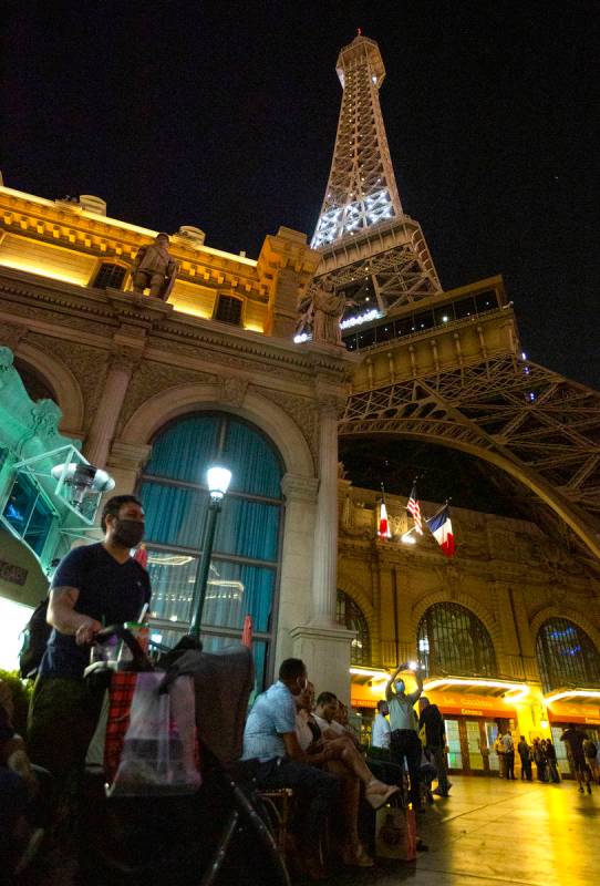 People linger outside Paris Las Vegas following a power outage, which resulted in a building ev ...