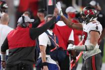 Tampa Bay Buccaneers head coach Bruce Arians high fives tight end Rob Gronkowski (87) as he lea ...