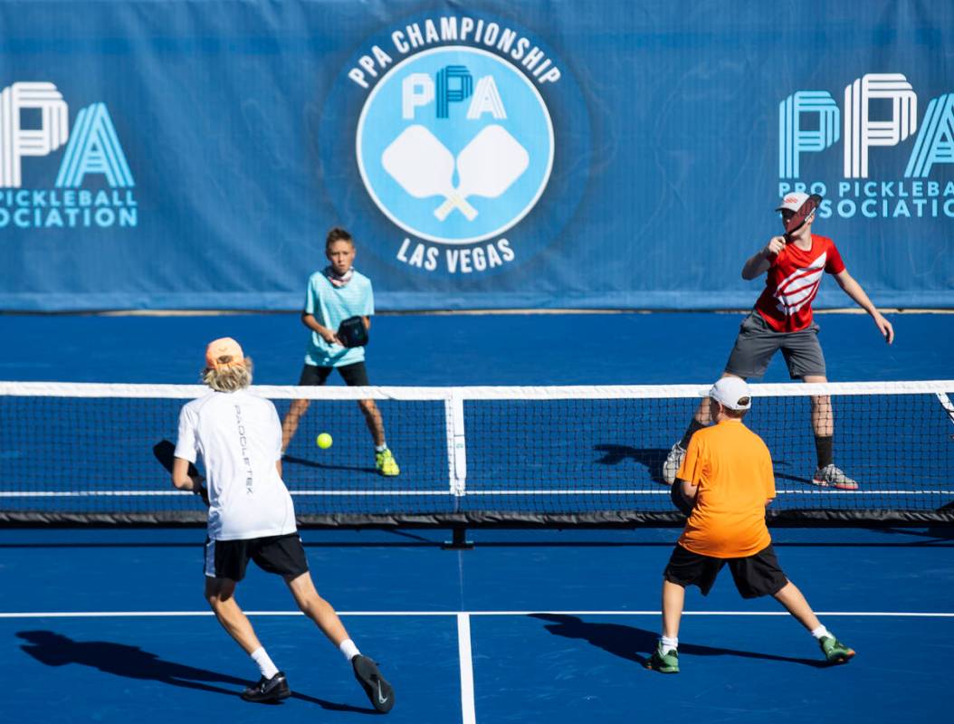 Jeff Ross, 11, left, Poster Barr, 14, compete against Hardy Owen, 12, left front, and his broth ...