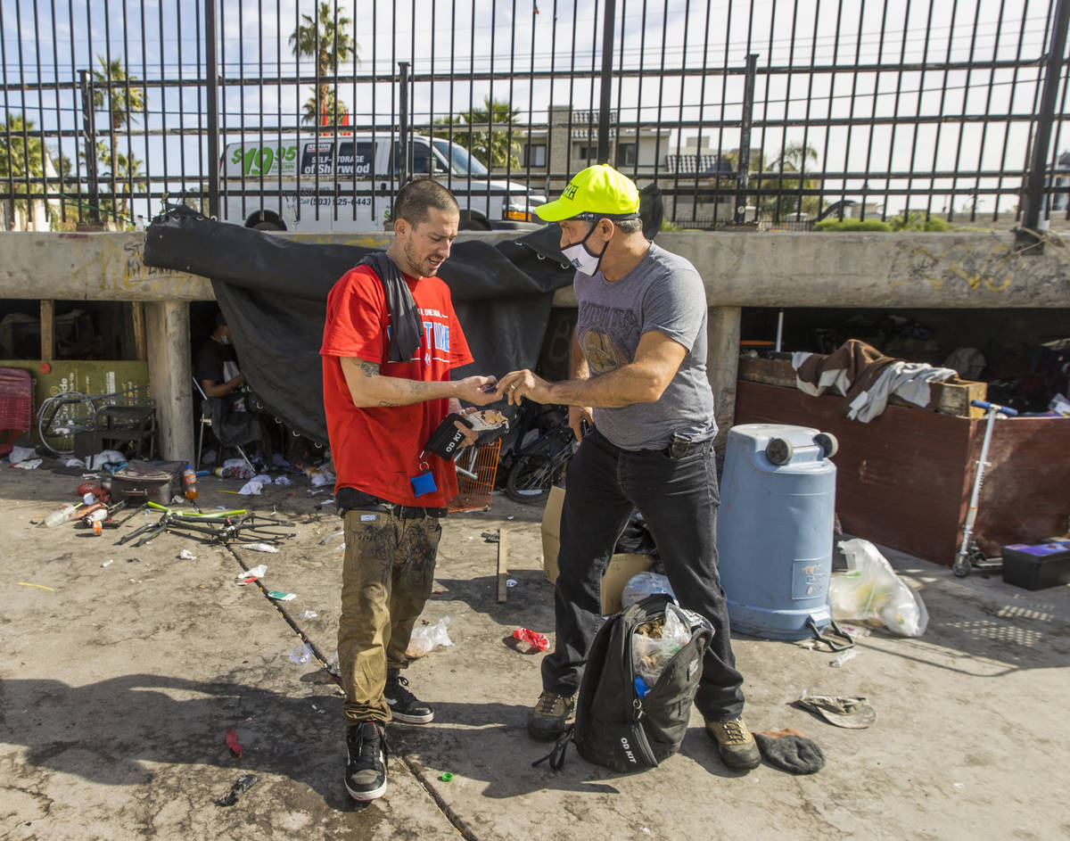 Crossroads CEO Dave Marlon, right, gives food and medical supplies to Nico (no last name) while ...