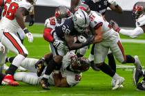 Las Vegas Raiders running back Josh Jacobs (28) is brought down by defensive end Ndamukong Suh ...