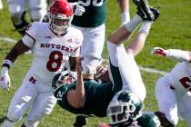 Michigan State quarterback Rocky Lombardi (12) jumps over Rutgers defensive back Lawrence Steve ...