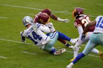 Dallas Cowboys quarterback Andy Dalton (14) is hit by Washington Football Team inside linebacke ...