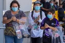 (From left) Vanessa, Cody, 14, and Ben, 10, Roberts use some hand sanitizer as the family walks ...