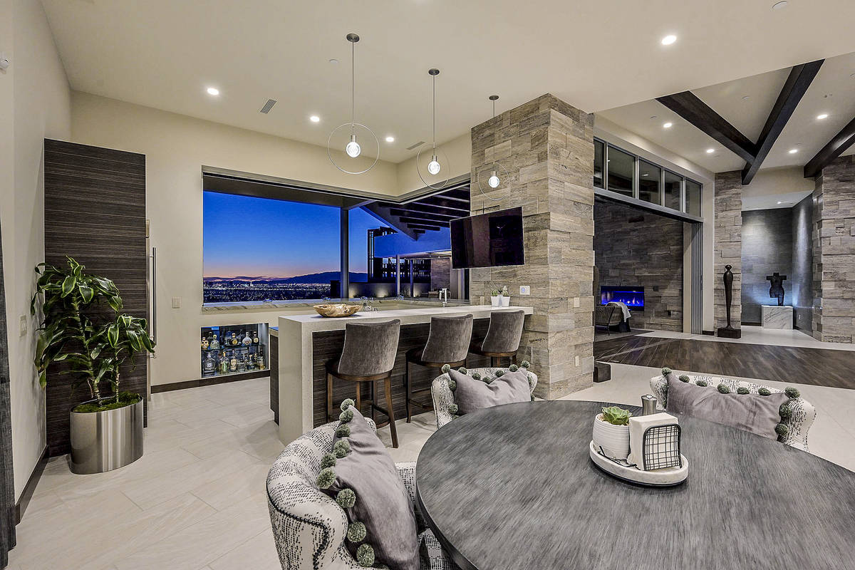 The kitchen bar extends to the pool area via a large window. Indoor/outdoor living spaces are i ...