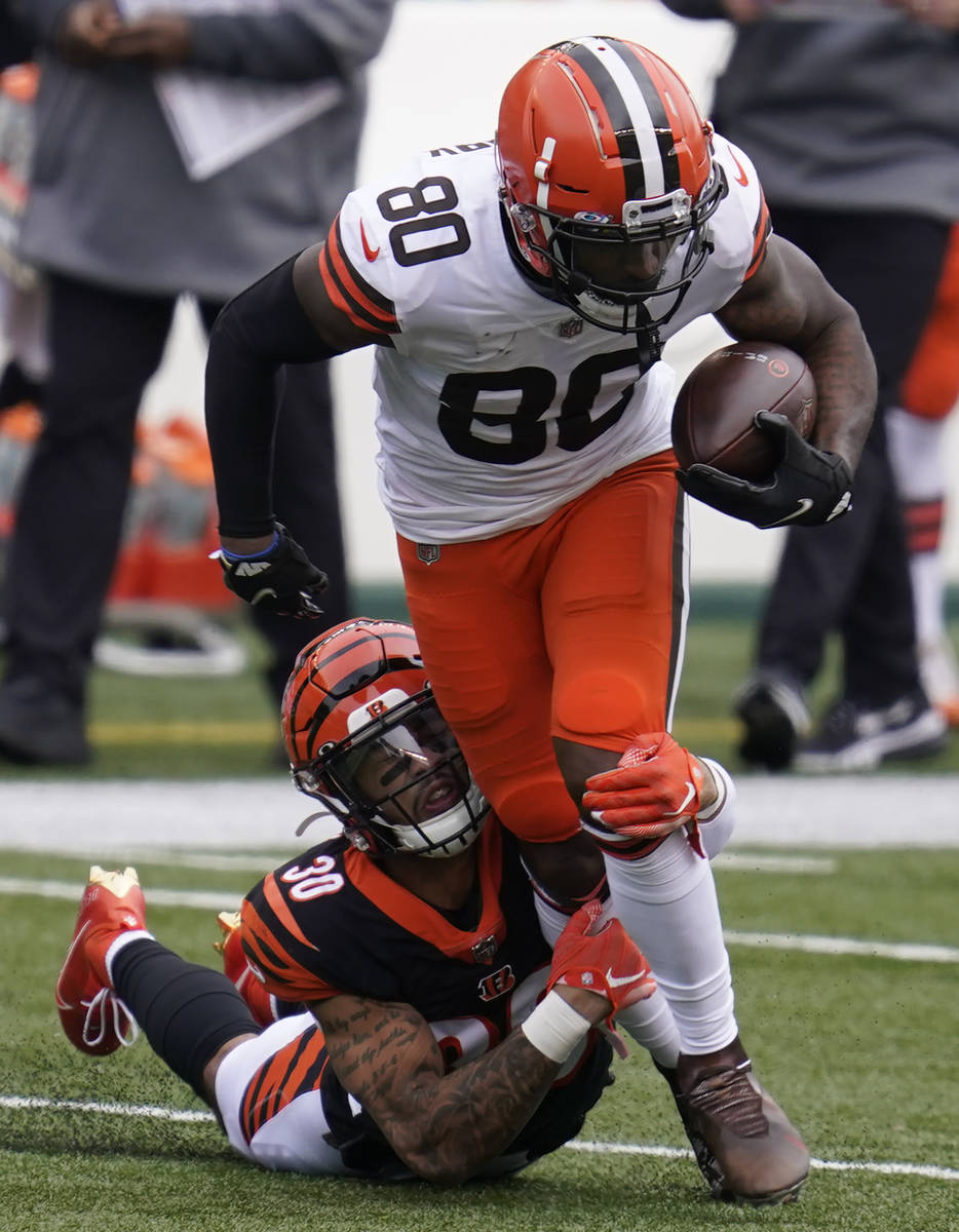 Cleveland Browns' Jarvis Landry (80) is tackled by Cincinnati Bengals' Jessie Bates (30) during ...