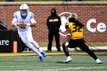 Kentucky quarterback Joey Gatewood, left, scrambles as Missouri linebacker Nick Bolton (32) def ...