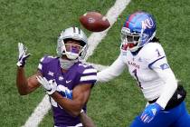 Kansas State wide receiver Chabastin Taylor (13) catches a long pass under pressure from Kansas ...
