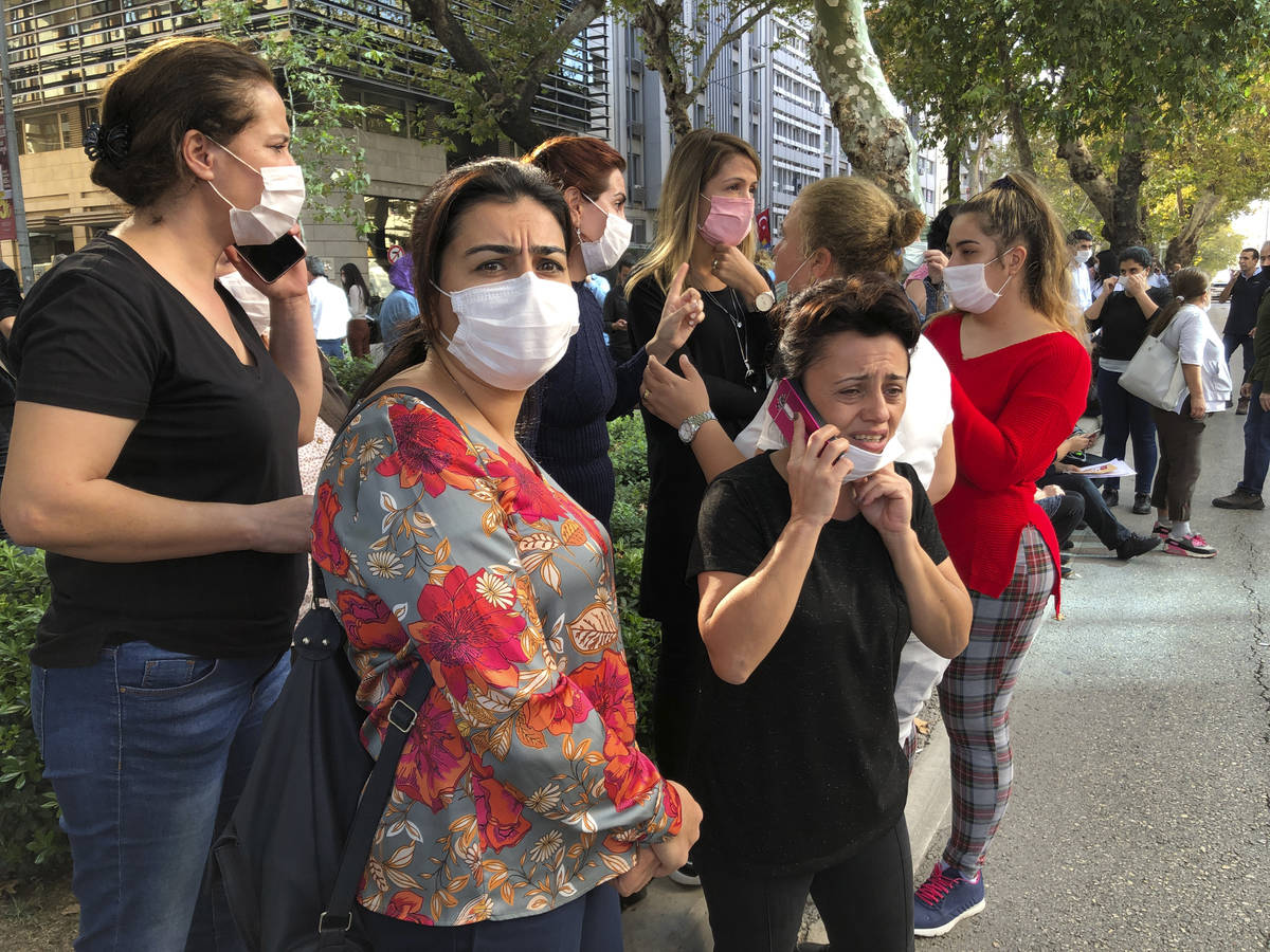 People stand outside their homes in Izmir, Turkey, Friday, Oct. 30, 2020, after a strong earthq ...