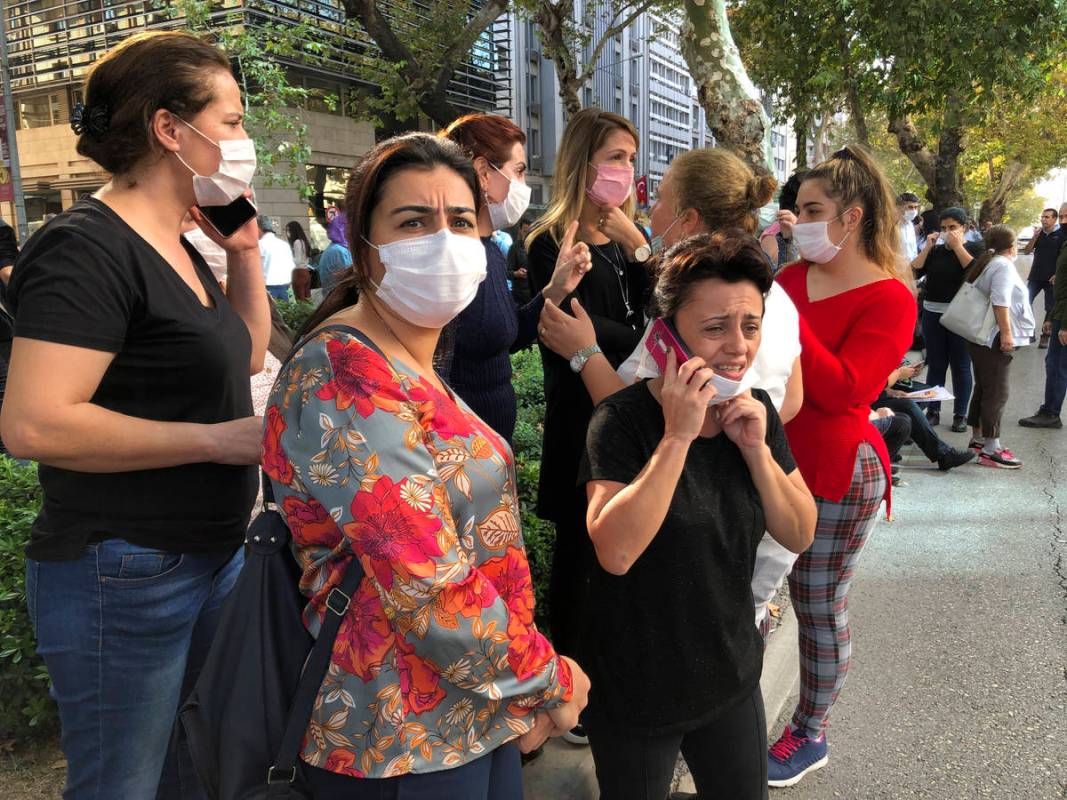 People stand outside their homes in Izmir, Turkey, Friday, Oct. 30, 2020, after a strong earthq ...