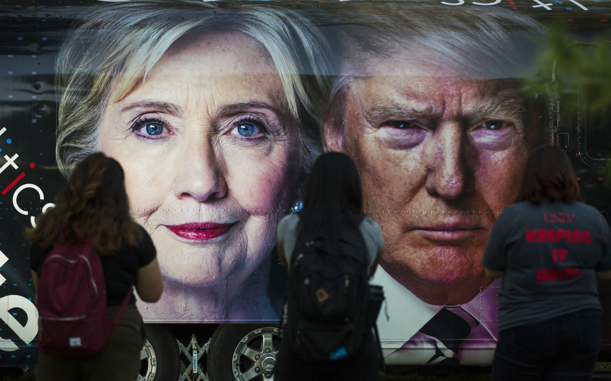 People take photos of a bus depicting Democratic presidential candidate Hillary Clinton and Rep ...