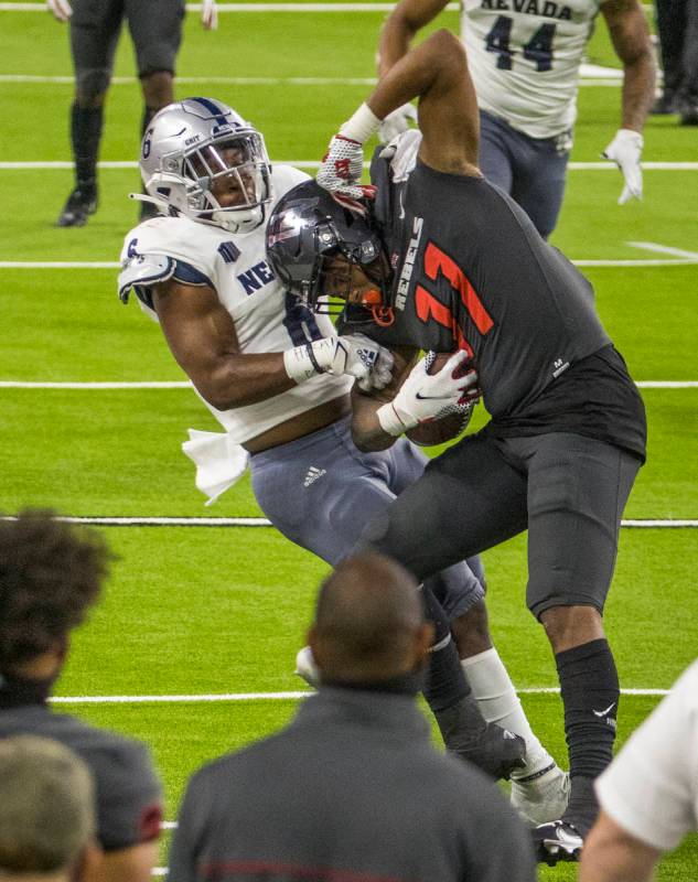 UNLV Rebels tight end Noah Bean (11, right) is stopped after a catch by Nevada Wolf Pack defens ...