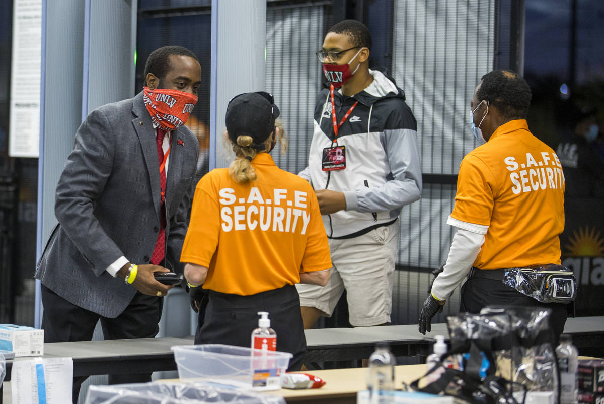 Fans William Wheeler, left, and Lawrence Murray, center, are checked by security as they enter ...