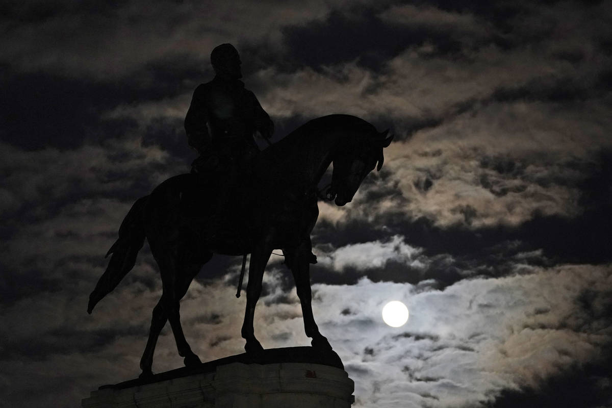 A full moon rises over the statue of Confederate Gen. Robert E. Lee on Monument Avenue in Richm ...