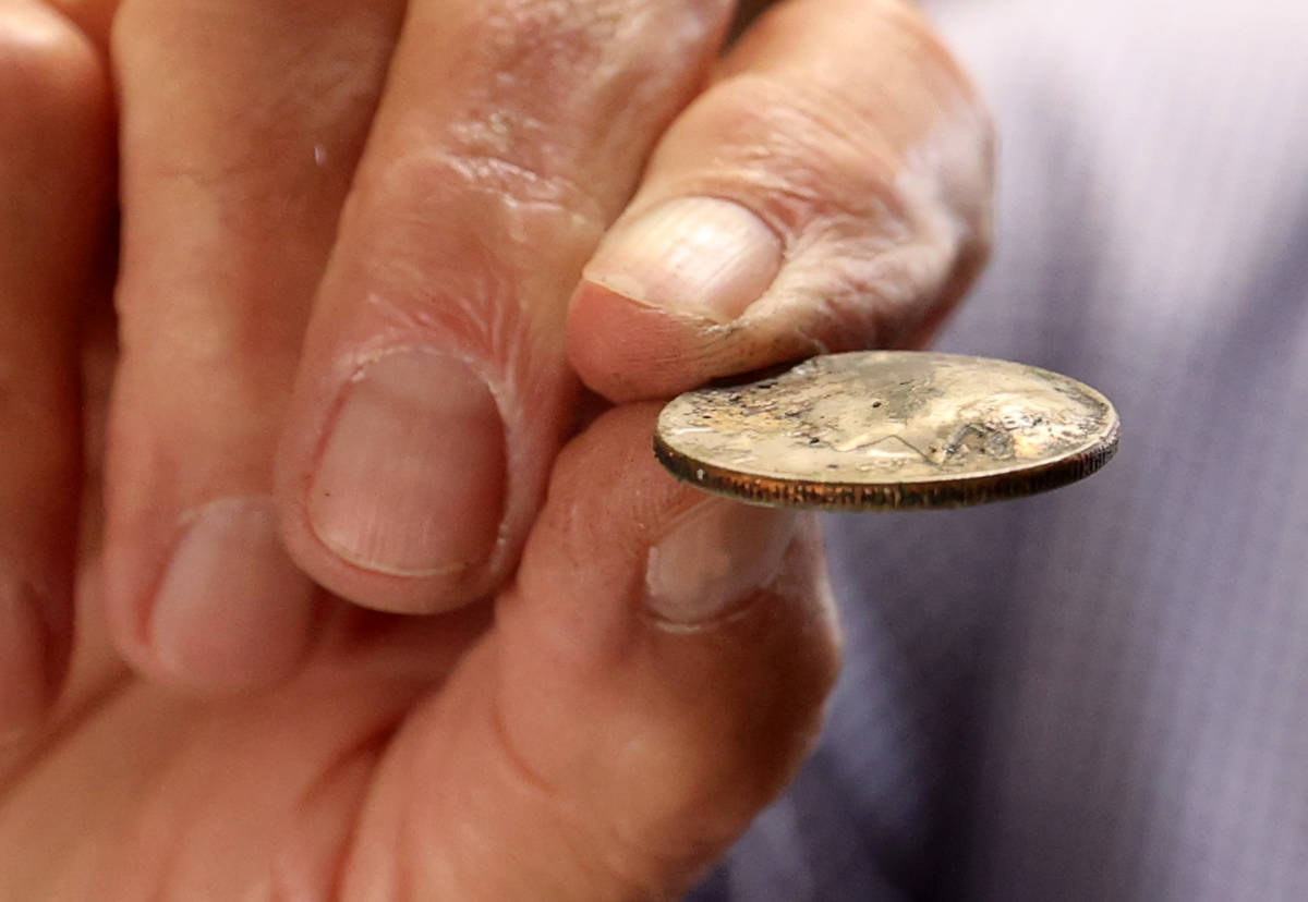 Charlie Lombardo, 72, shows a burned and bubbled coin from the MGM Grand in his Henderson home ...
