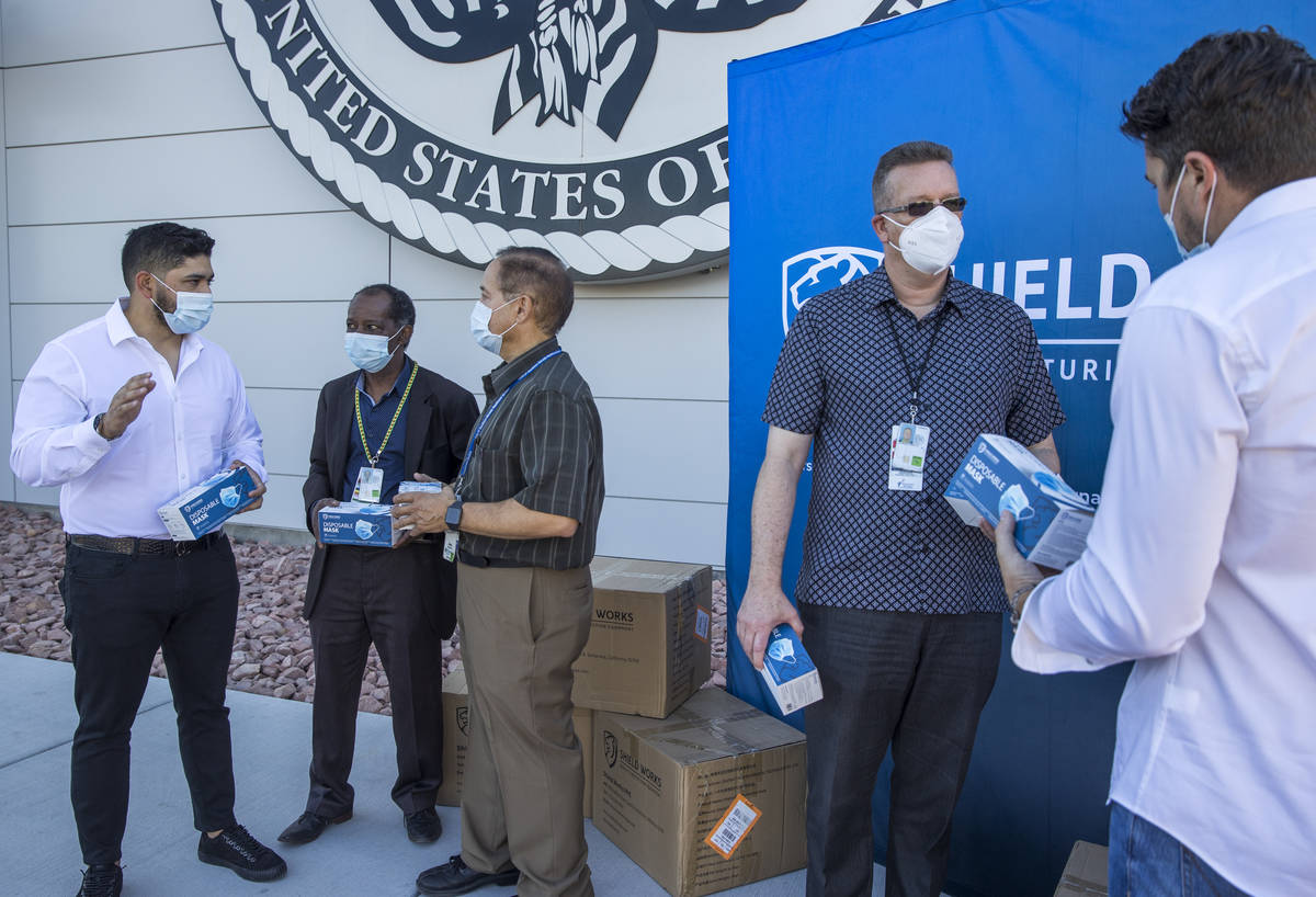 The owners of Shield Works gather with VA Hospital personnel to donate 100,000 masks to the fac ...