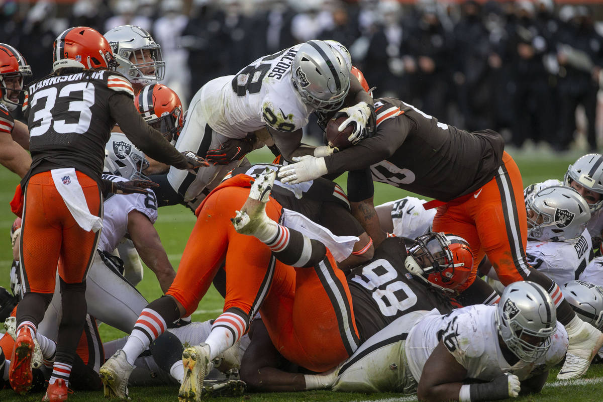 Las Vegas Raiders running back Josh Jacobs (28) leaps over against the Cleveland Browns defende ...