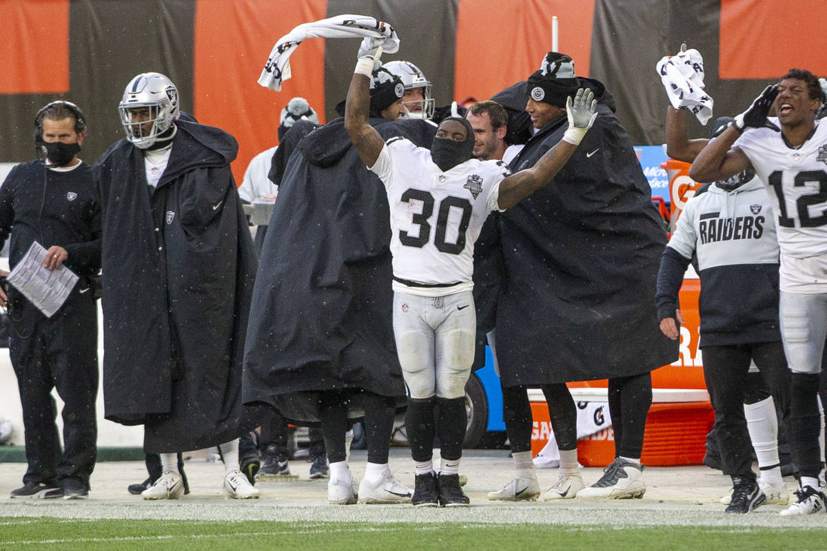 Las Vegas Raiders running back Jalen Richard (30) waves a towel in the air to celebrate a defen ...
