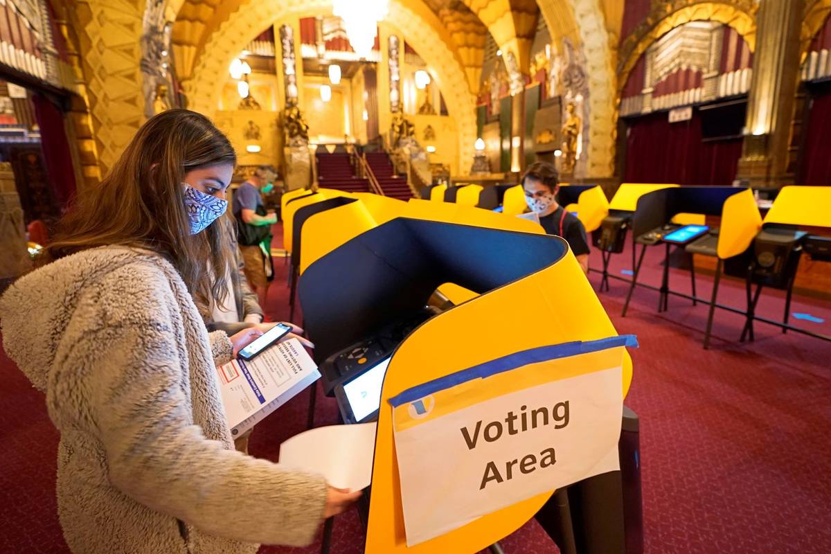 People wait in line to vote in-person outside the Hollywood Pantages Theatre, an official Los A ...