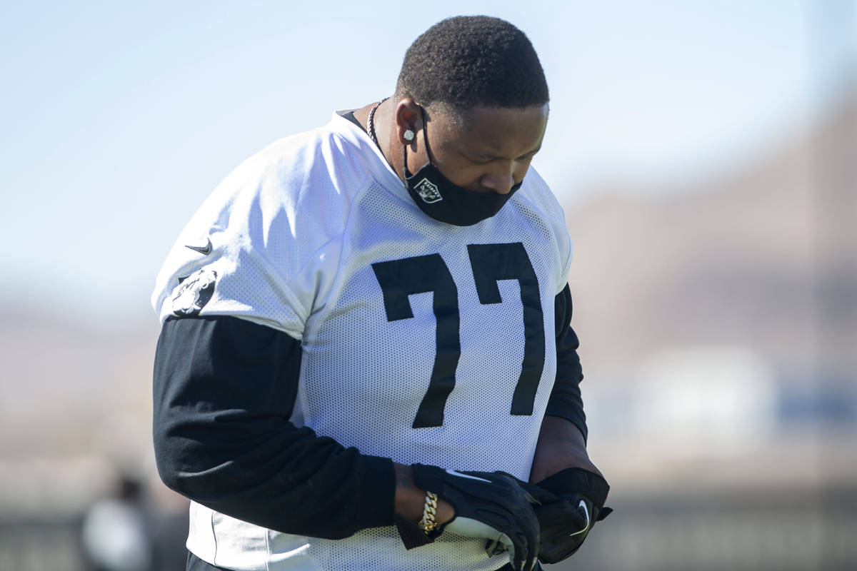 Las Vegas Raiders offensive tackle Trent Brown (77) warms up with a mask on during a practice ...