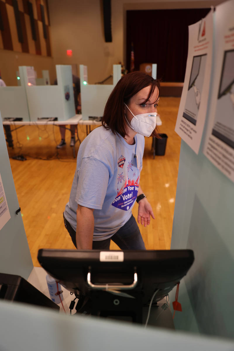 Jen Kennedy of Henderson sanitizes a voting booth at Historic Fifth Street School in downtown L ...
