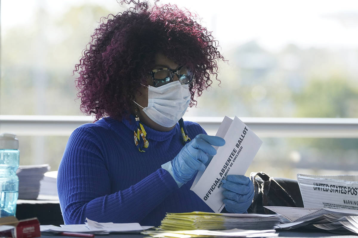 A worker at the Fulton County Board of Registration and Elections works to process absentee bal ...