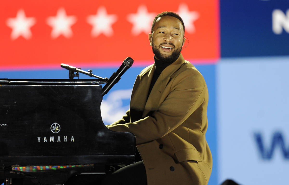 Performer John Legend plays the piano during a drive-in get out the vote rally featuring Democr ...