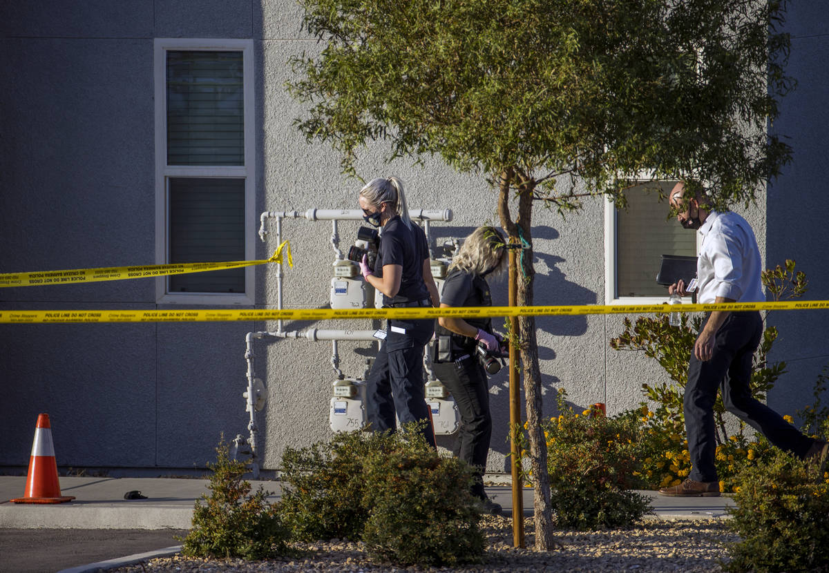 Crime scene investigators document the scene outside after four were killed and one injured in ...