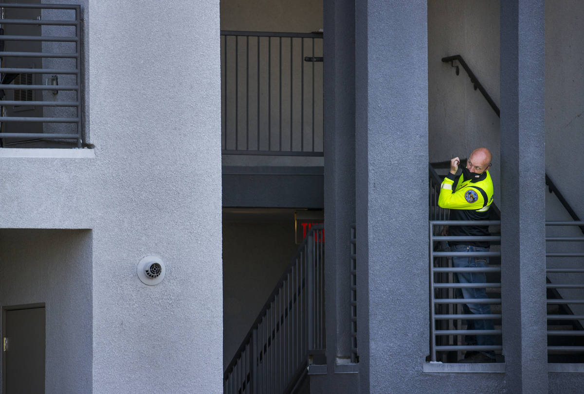 An officer looks out from a stairwell after four were killed and one injured in police shooting ...