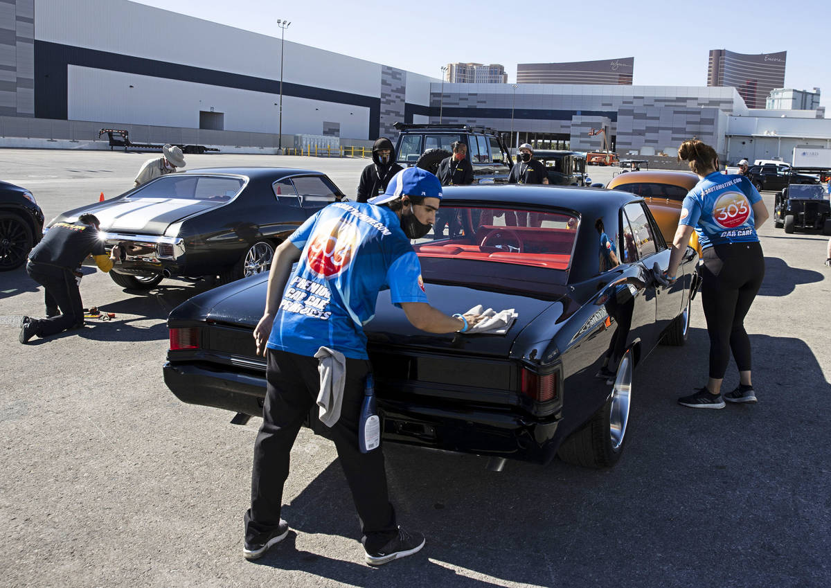 Auto detailer Max Zabata, center, details a 1967 Chevy Malibu as cars are lined up to be inspec ...