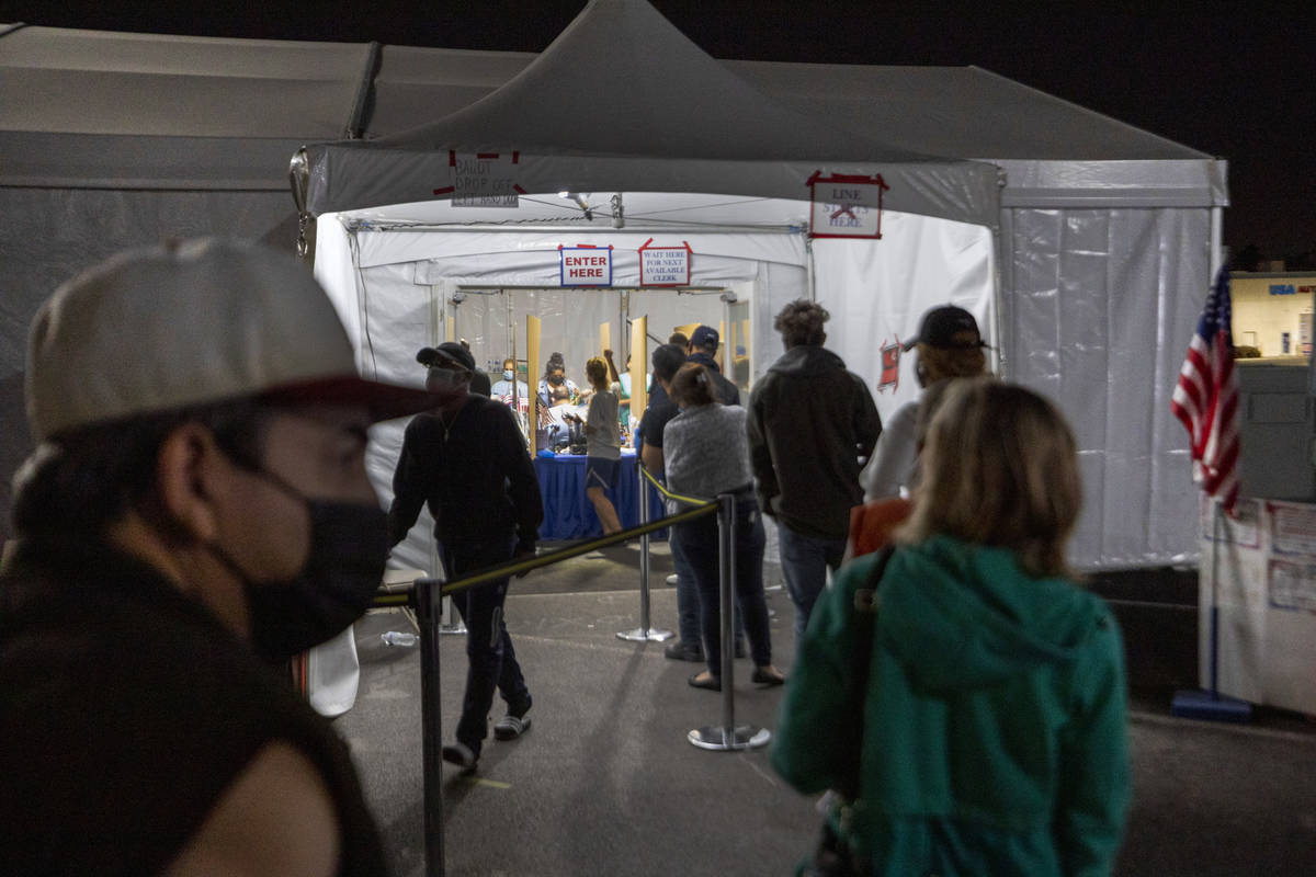 Individuals wait in line to cast their ballot at the Boulevard Mall polling station before it c ...