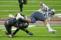 UNR Wolf Pack running back Toa Taua (35) is taken down by UNLV Rebels defensive back Dominic Br ...