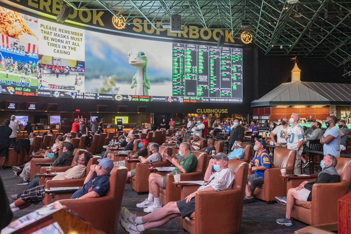 Individuals watch games at the Westgate Sportsbook during opening weekend, in Las Vegas on Sund ...