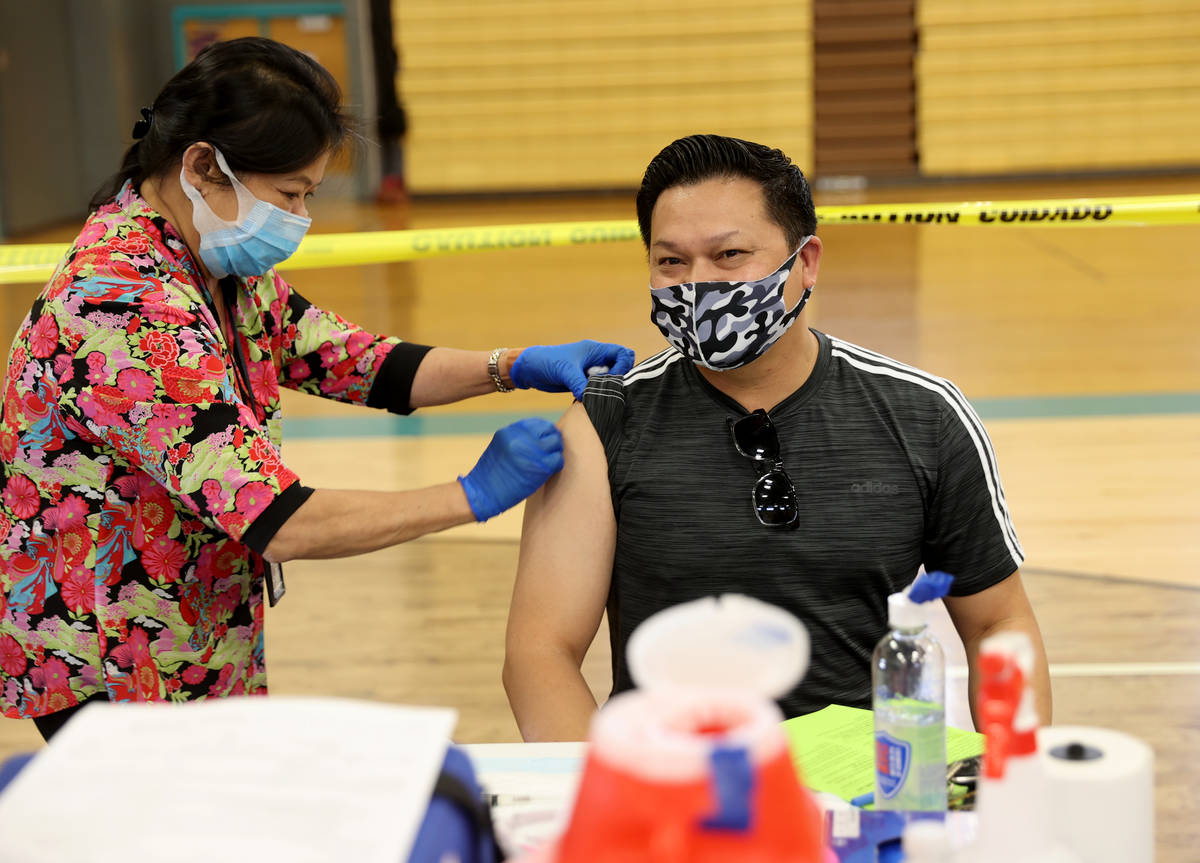 Jaime Valdecantos, 44, of Henderson, gets a flu vaccine from Nenetter Gonzales during a Souther ...