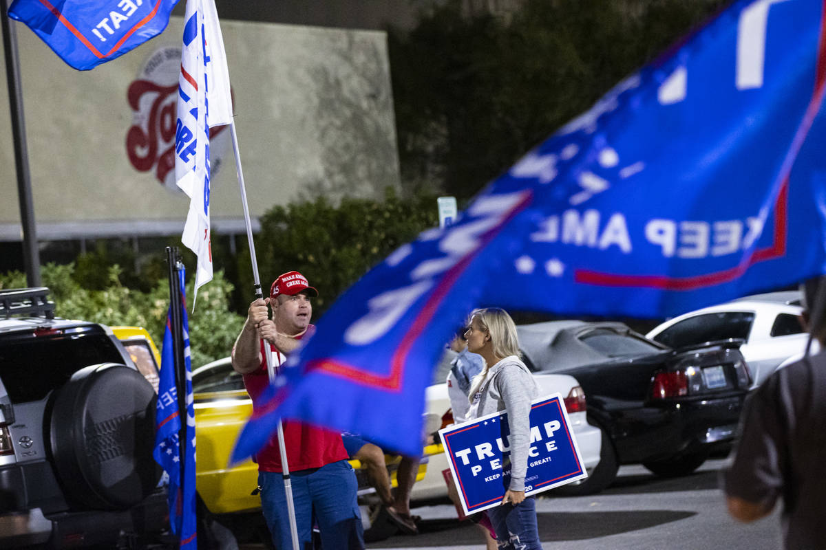 Supporters of President Donald Trump, including Lance Baker, of Las Vegas, left, talks with con ...