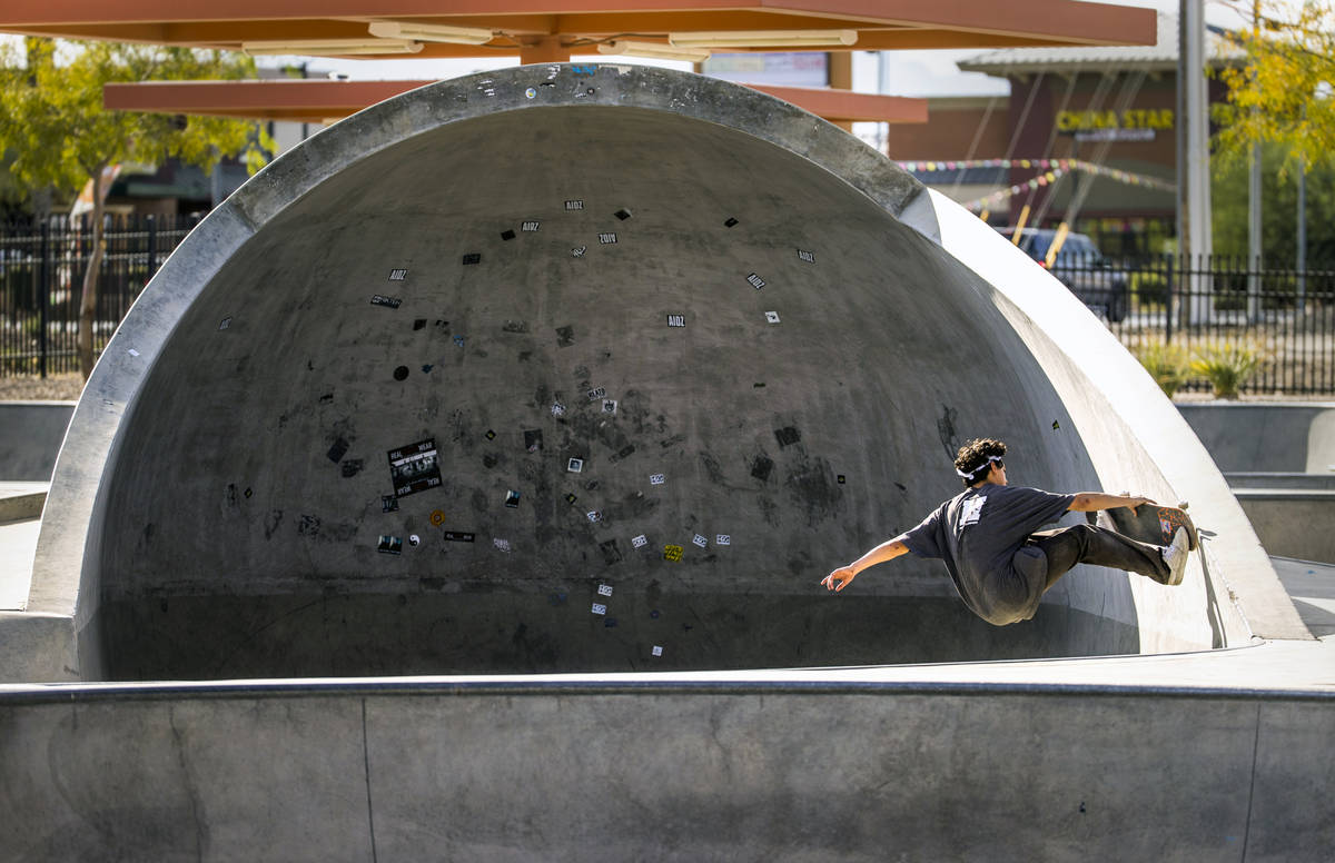 Skateboarder P.J. Dellatan grabs his board on the side of a half-covered bowl at the Craig Ranc ...