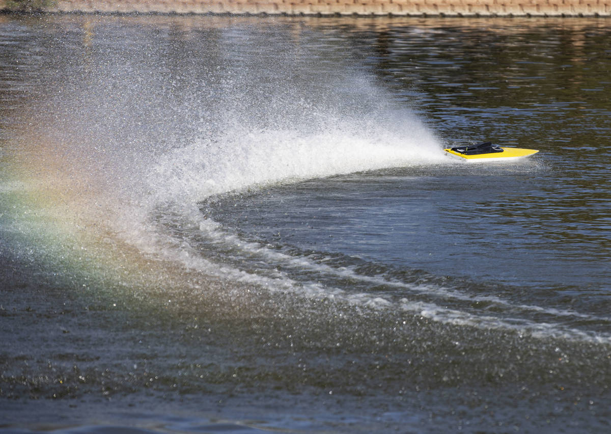 Remotely controlled high-performance electric race boat makes splash as it races on the pond at ...
