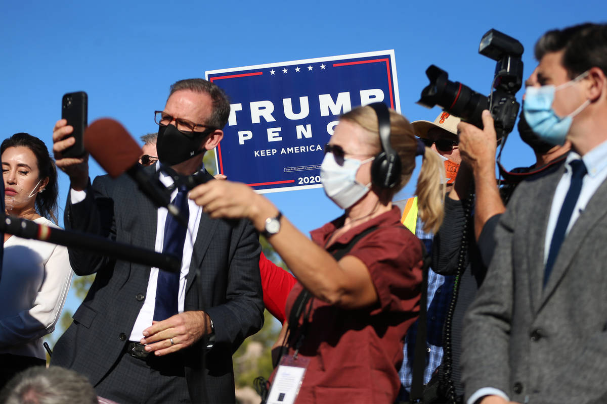 A supporter for President Donald Trump raises a banner during a press conference hosted by the ...