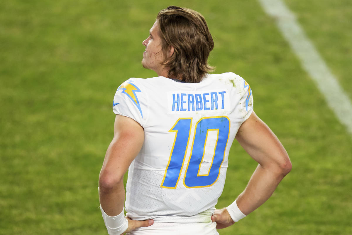 Los Angeles Chargers quarterback Justin Herbert (10) stands on the  sidelines against the Denver …